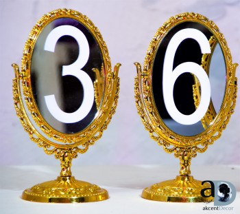 Нумераторы  на зеркале в овальной раме золотого цвета